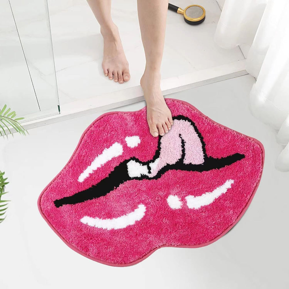 The VibeCore Pink Lips Tongue Out Accent Rug in a bathroom, featuring a vibrant pink lip and tongue design. This playful rug adds a touch of fun and comfort to the space, with its soft texture and non-slip backing ensuring safety even in wet environments.