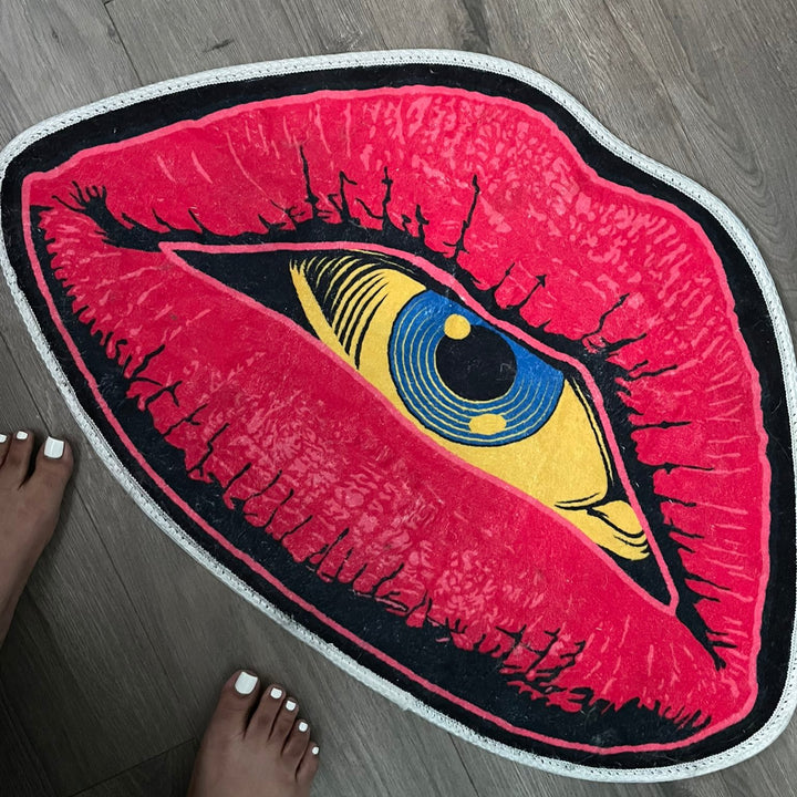 VibeCore Psychic Lips Accent Rug placed by feet, showcasing its bold lips design and mystical details, adding a surreal and artistic touch to the space.