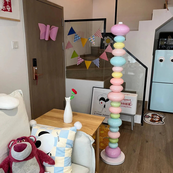 VibeCore Rainbow Candy Floor Lamp In Apartment – The colorful Rainbow Candy Floor Lamp glowing in an apartment setting, with its playful candy-inspired design and sleek metal base adding a vibrant touch to the room's decor.