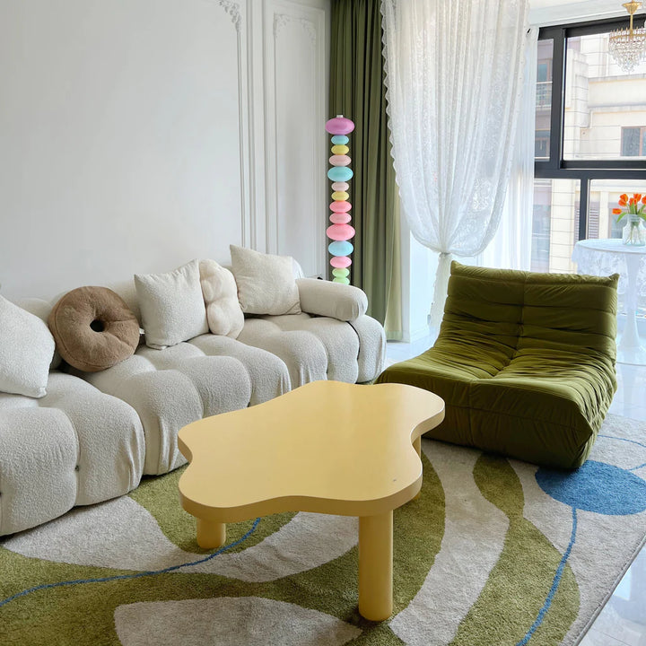 The Rainbow Candy Floor Lamp standing in an apartment living room, showcasing its colorful glass design and sleek metal base, adding a bold, stylish element to the space even when unlit.