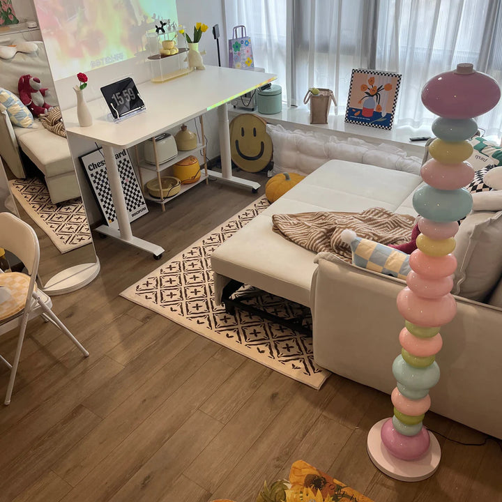  A top-down view of the unlit Rainbow Candy Floor Lamp in an apartment living room, highlighting its colorful glass design and sleek metal base, perfect for adding a playful touch to the space even when not illuminated.