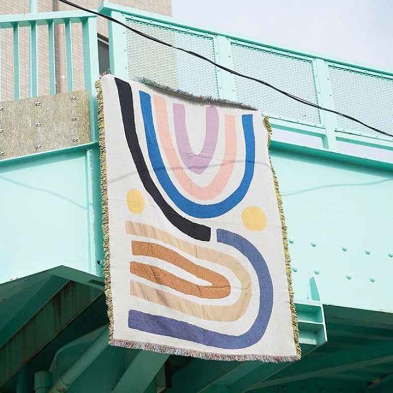 VibeCore Rainbow Dreams Woven Cotton Blanket Hanging on Balcony - Colorful Bohemian Outdoor Decor with Reversible Textile Art