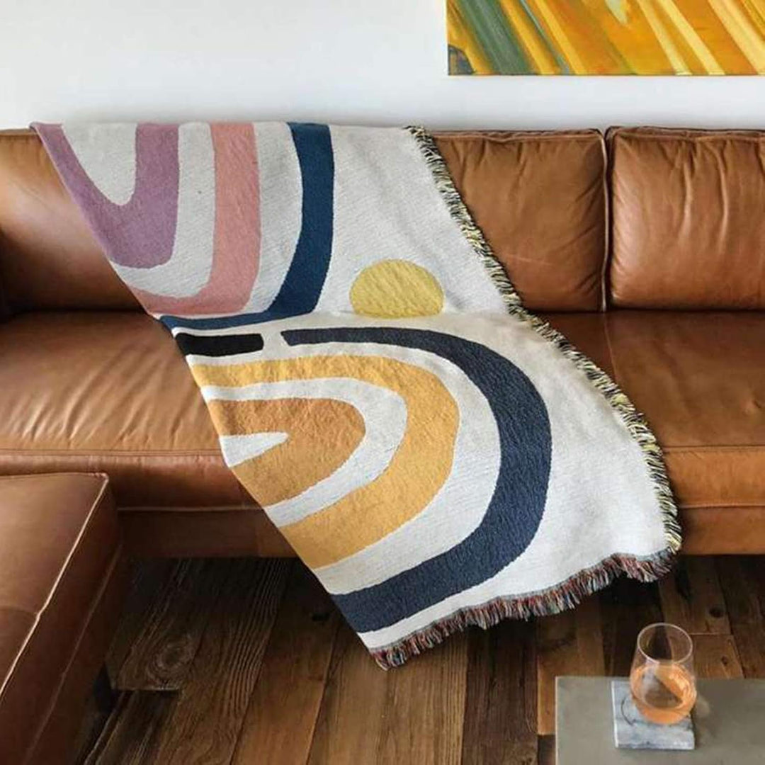 VibeCore Rainbow Dreams Woven Cotton Blanket on Leather Couch – Colorful Bohemian Throw for Contrasting Modern Decor