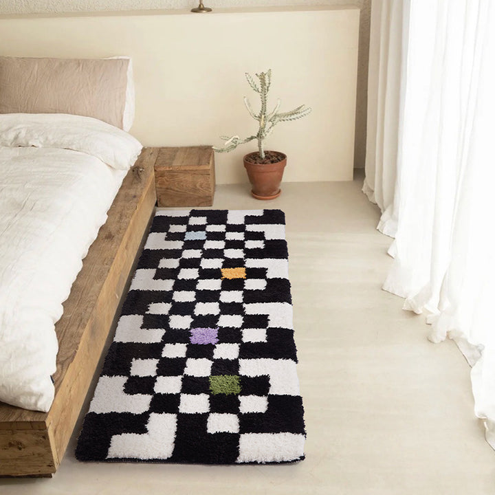 The VibeCore Retro Remix Accent Rug with a bold checkered design, placed next to a bed, adding a pop of color and retro vibe to the room. The plush texture and stylish pattern make it a standout piece.