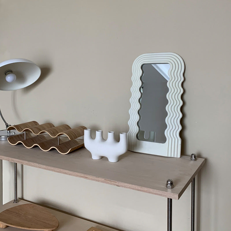VibeCore Retro Wave Mirror in white, displayed on a console table, featuring its wave-shaped resin frame and sleek mirror lens, creating a unique and stylish focal point in the room.