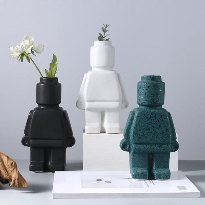 Aesthetic robot vases in white, black, and turquoise featuring sleek minimalist designs with pop-culture influence perfect for adding bold artistic touches to shelves, tables, or modern home decor.