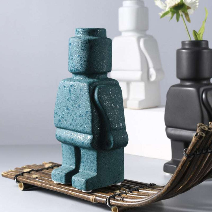 Aesthetic robot vase in turquoise with a close-up view showcasing its sleek minimalist design and pop-culture influence perfect for adding a bold artistic touch to modern home decor.