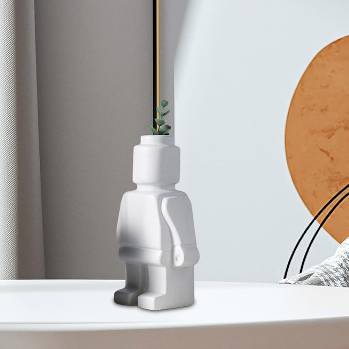 Aesthetic robot vase in white on a table featuring a sleek minimalist design with pop-culture influence perfect for adding a bold artistic touch to modern home decor.