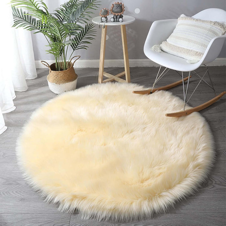 VibeCore Round Faux Fur Accent Rug in beige on the floor. Soft, fluffy texture with a non-slip backing, ideal for adding comfort to bedrooms, living rooms, or dorm rooms. Easy to clean, available in multiple colors.