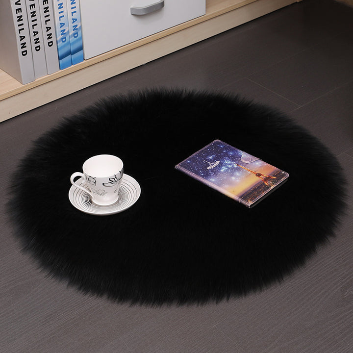 VibeCore Round Faux Fur Accent Rug in black on the floor, also used as a seat cover. Soft and fluffy with a non-slip backing, perfect for dorm rooms, bedrooms, or living rooms. Easy to clean, available in multiple colors.