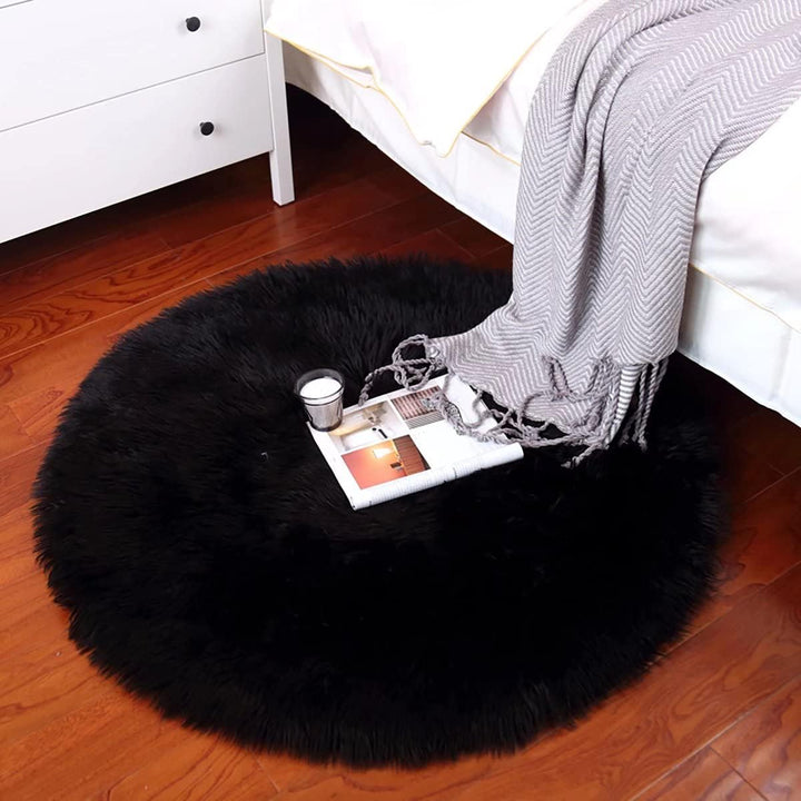 VibeCore Round Faux Fur Accent Rug in black on the floor. Soft, fluffy texture with a non-slip backing, perfect for bedrooms, living rooms, or dorm rooms. Easy to clean, available in multiple colors.