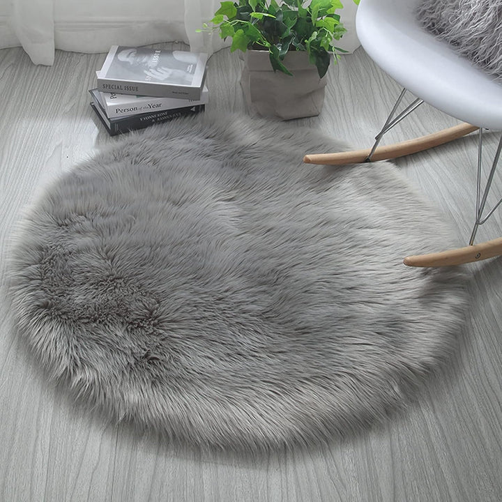 VibeCore Round Faux Fur Accent Rug in gray on the floor. Soft, fluffy texture with a non-slip backing, perfect for bedrooms, living rooms, or dorm rooms. Easy to clean, available in multiple colors.