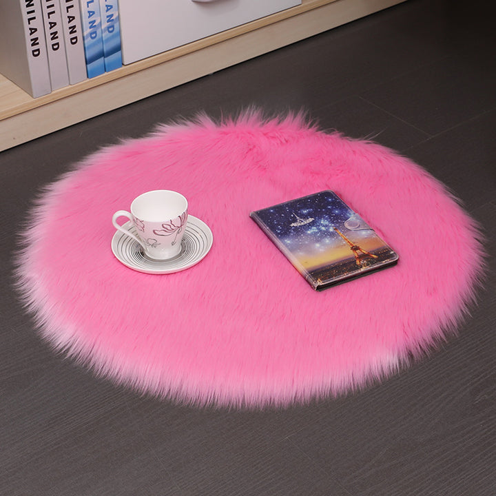 VibeCore Round Faux Fur Accent Rug in hot pink on the floor, also used as a seat cover. Soft and fluffy with a non-slip backing, perfect for dorm rooms, bedrooms, or living rooms. Easy to clean, available in multiple colors.
