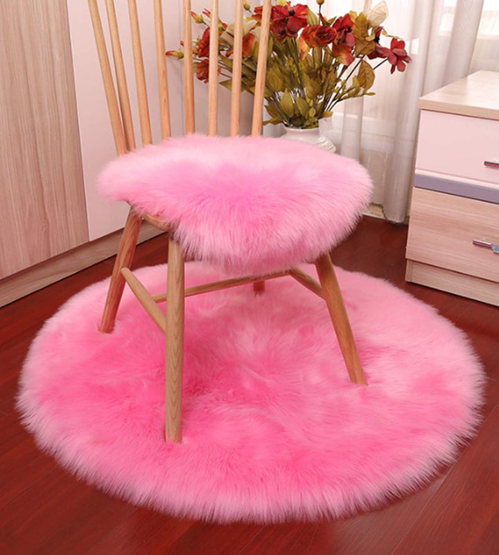 VibeCore Round Faux Fur Accent Rug in hot pink on the floor, also used as a seat cover. Soft and fluffy with a non-slip backing, perfect for dorm rooms, bedrooms, or living rooms. Easy to clean, available in multiple colors.