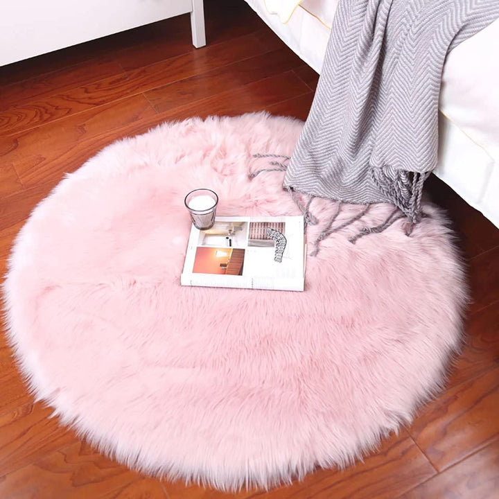 The VibeCore Round Faux Fur Accent Rug in Light Pink placed on the floor, displaying its soft, plush texture and sleek round shape, perfect for enhancing the comfort and style of any room.