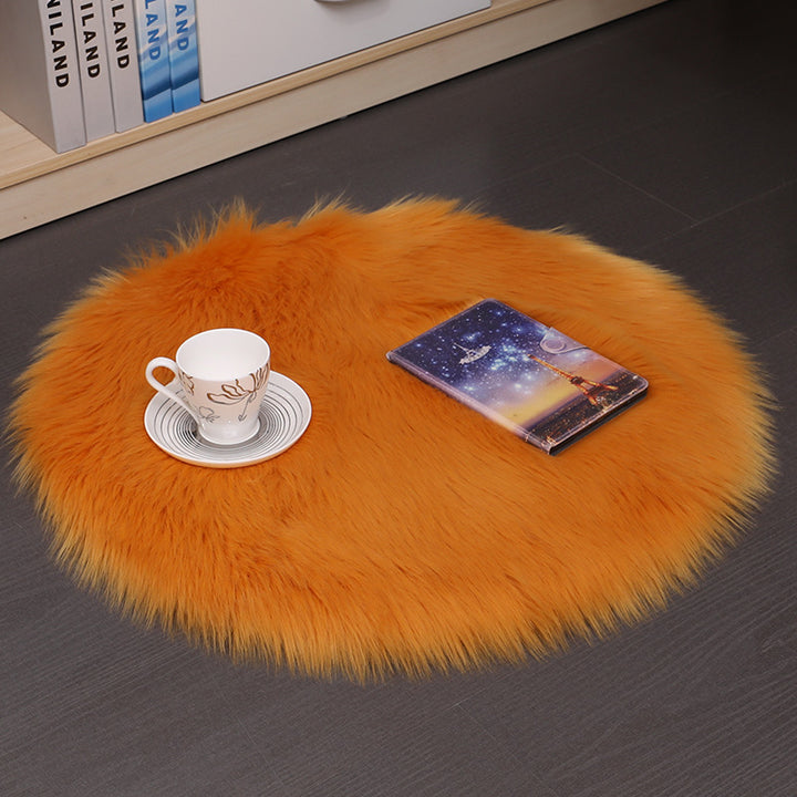 VibeCore Round Faux Fur Accent Rug in orange on the floor. Soft, fluffy texture with a non-slip backing, ideal for adding comfort to bedrooms, living rooms, or dorm rooms. Easy to clean, available in multiple colors.