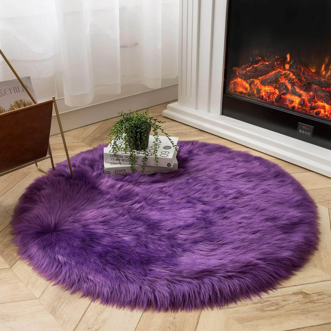 VibeCore Round Faux Fur Accent Rug in purple on the floor, also used as a seat cover. Soft and fluffy with a non-slip backing, perfect for dorm rooms, bedrooms, or living rooms. Easy to clean, available in multiple colors.