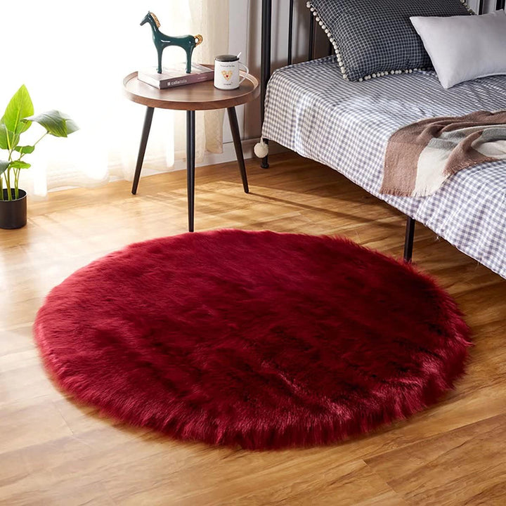 VibeCore Round Faux Fur Accent Rug in red on the floor. Soft, fluffy texture with a non-slip backing, ideal for adding comfort to bedrooms, living rooms, or dorm rooms. Easy to clean, available in multiple colors.
