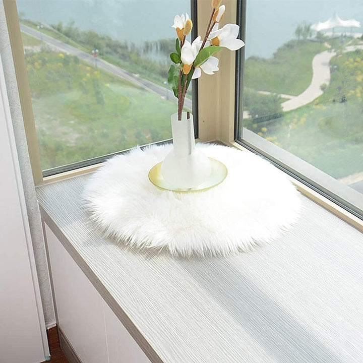 The VibeCore Round Faux Fur Accent Rug in White used as a placemat, showcasing its plush, soft texture and versatile design, perfect for adding a cozy, luxurious touch to any dining or living space.