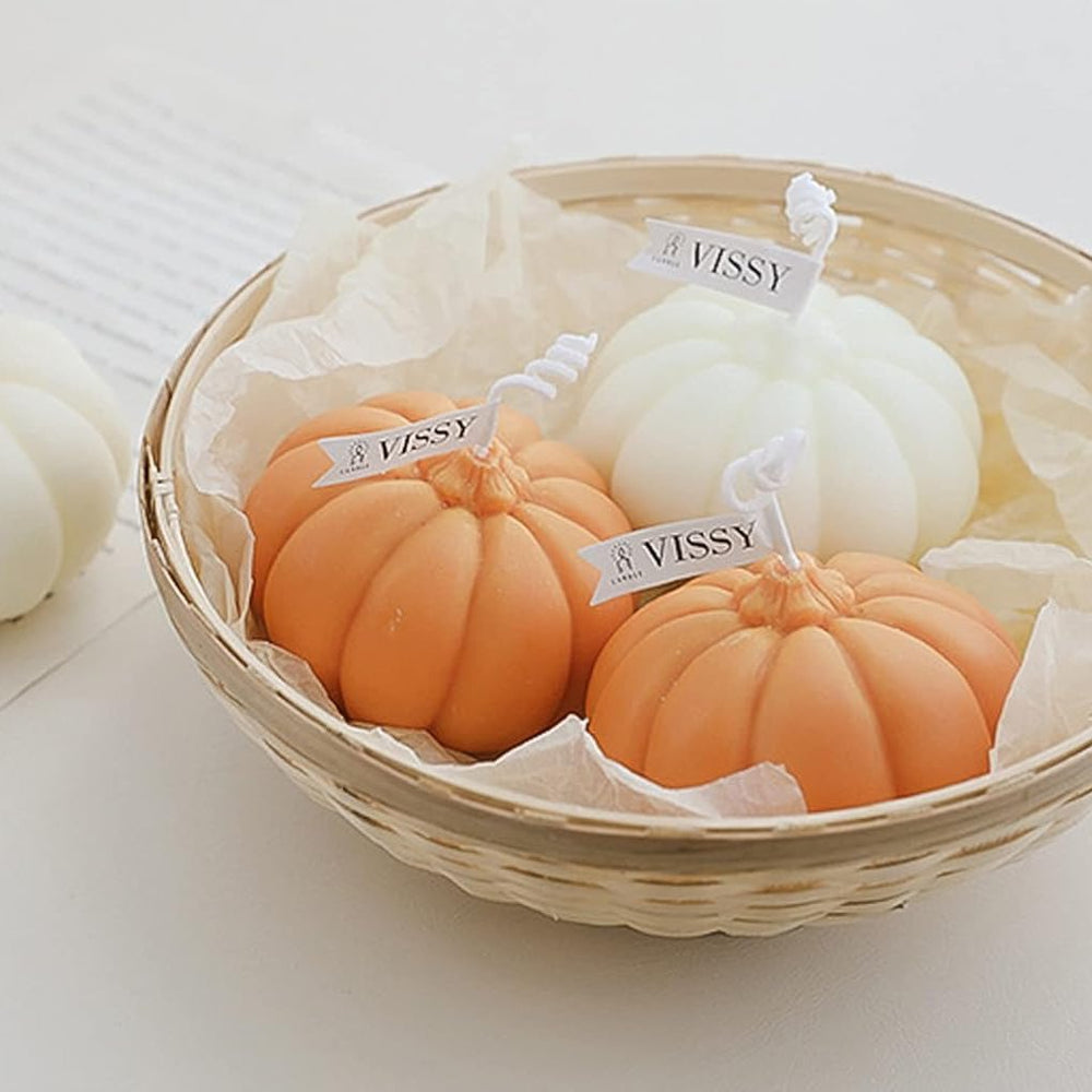 Two orange and white scented pumpkin candles in a basket, featuring cozy pumpkin-shaped designs and warm fragrances, perfect for adding a seasonal touch to your fall decor.