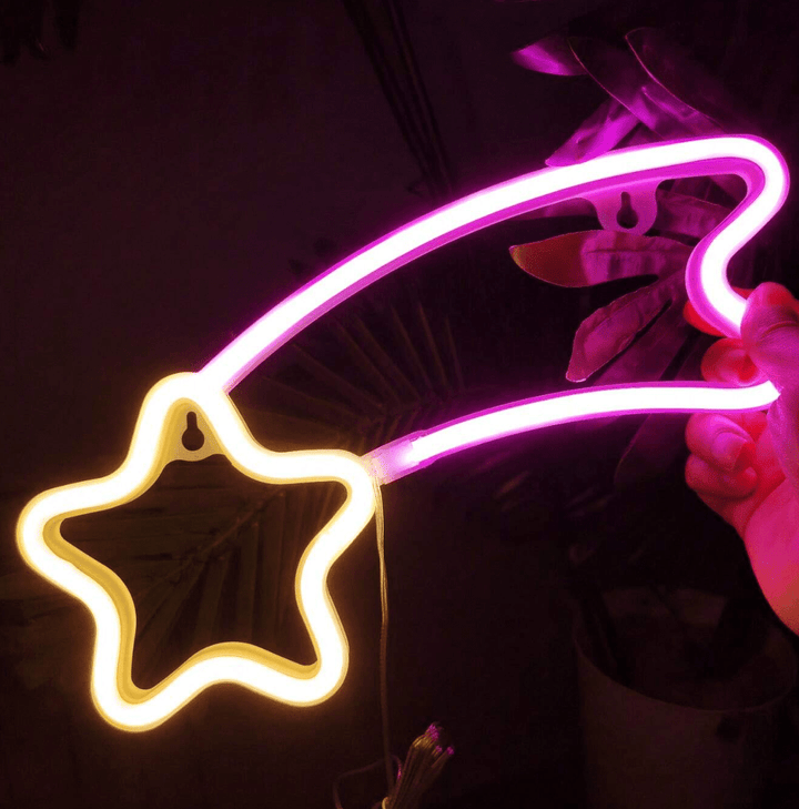 VibeCore Shooting Star Neon Light in pink and yellow, glowing brightly to create a dreamy, celestial atmosphere in the space.