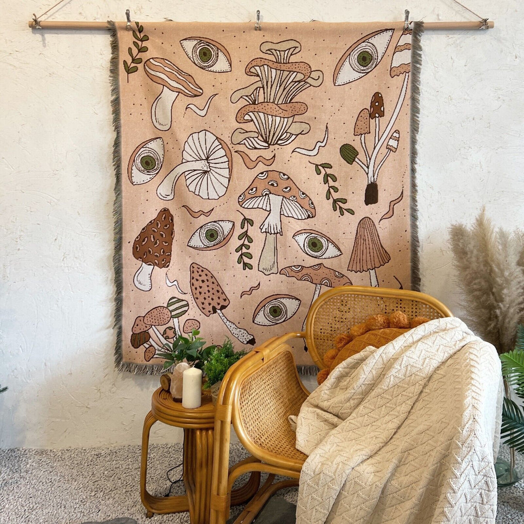 VibeCore Shroom Magic Woven Blanket displayed as a wall hanging, highlighting its enchanting mushroom design and reversible woven texture.
