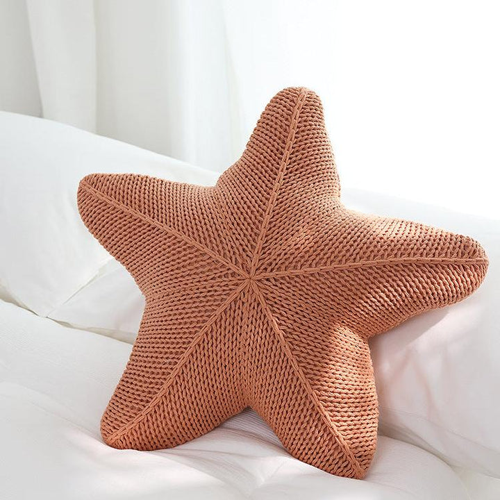 VibeCore Starfish Hand-Knitted Throw Pillow in coral, showcasing the starfish shape with a hand-knitted texture for a cozy, coastal vibe.