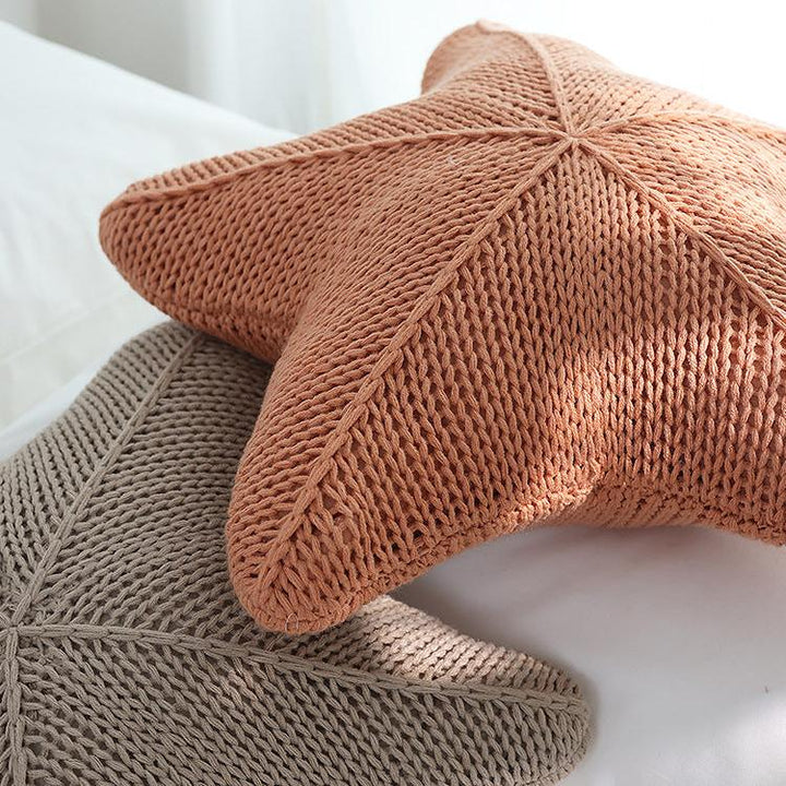 Close-up view of two VibeCore Starfish Hand-Knitted Throw Pillows, highlighting their intricate knit texture and coastal starfish design.