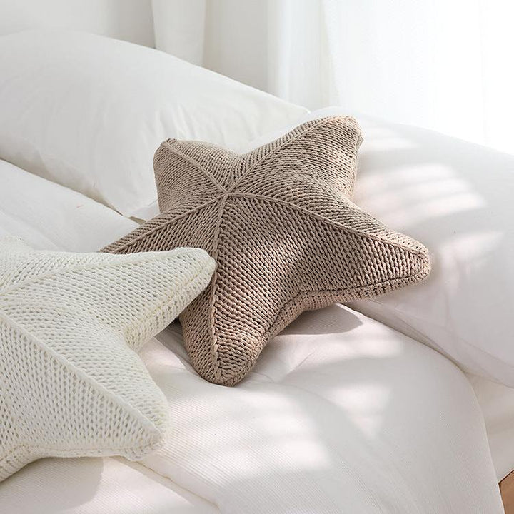 Two VibeCore Starfish Hand-Knitted Throw Pillows placed on a couch, showcasing their cozy, handcrafted knit texture and beachy starfish design.