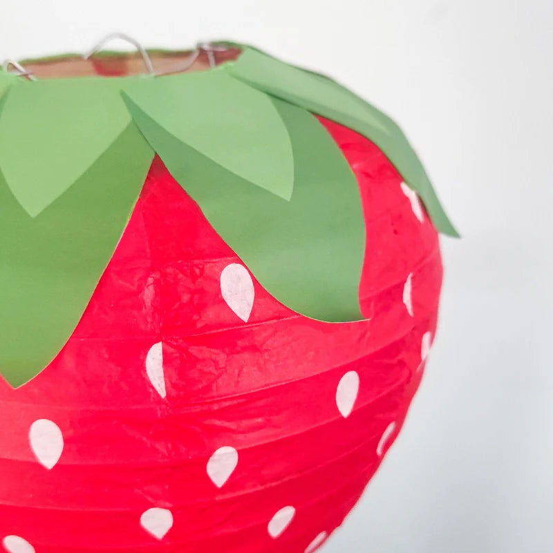 Close-up view of the VibeCore Strawberry Paper Lantern Pendant, showcasing the detailed strawberry design and printed leaves, highlighting its cute and playful aesthetic.