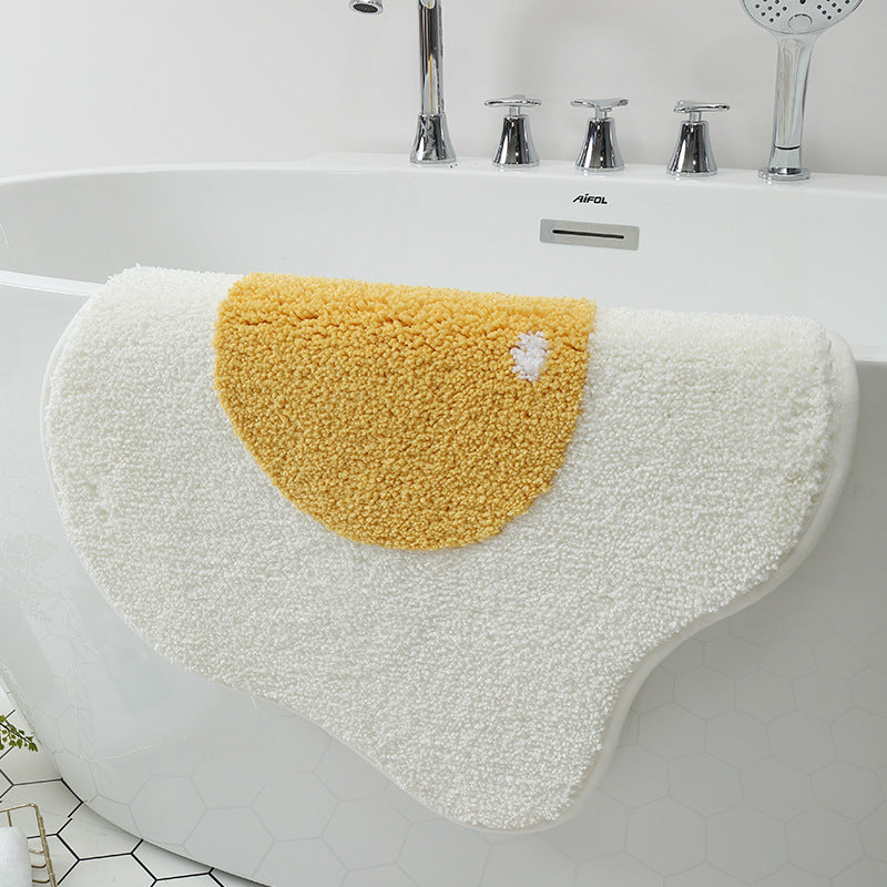 VibeCore Sunny-Side Up Egg Accent Rug strung on a tub, highlighting its playful fried egg design, soft plush texture, and non-slip backing. A cute rug that adds a quirky touch to any space, perfect for modern bedroom, dorm, or living room decor.