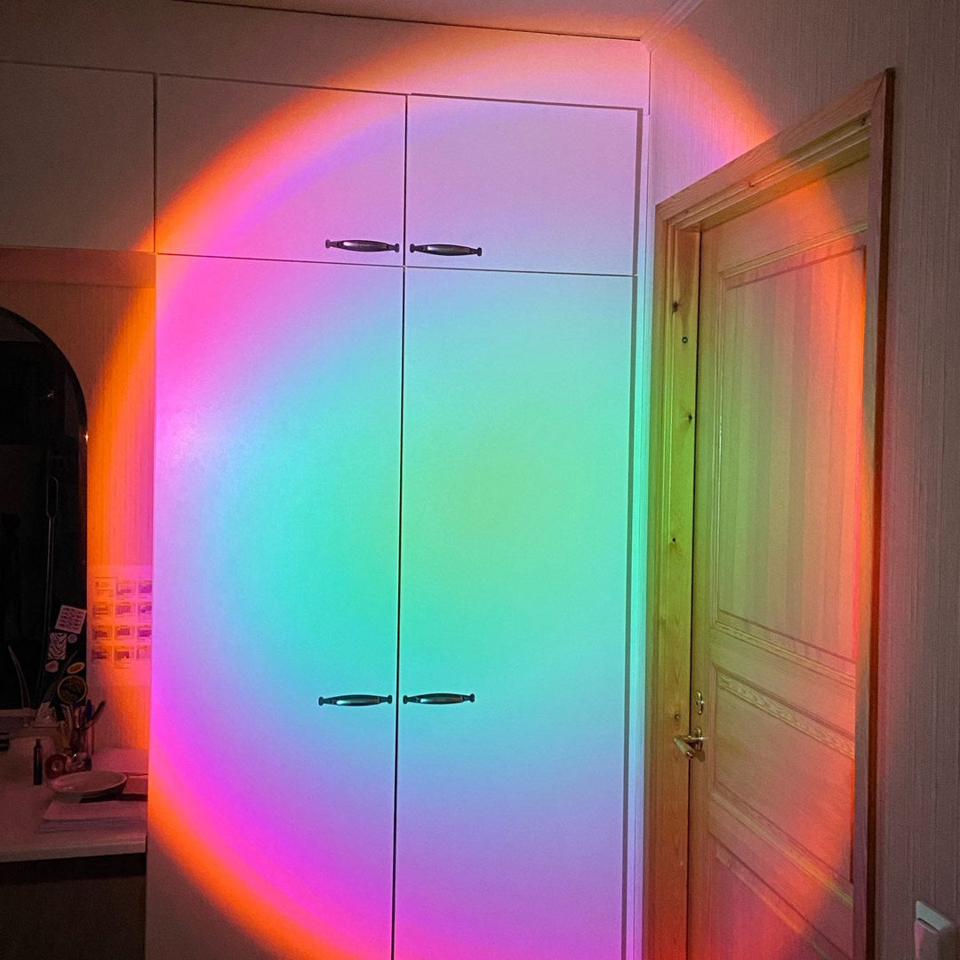 VibeCore Sunset Lamp with a green interior and pink exterior, casting a soft and colorful glow on the bedroom wall, creating a cozy and aesthetic ambiance.