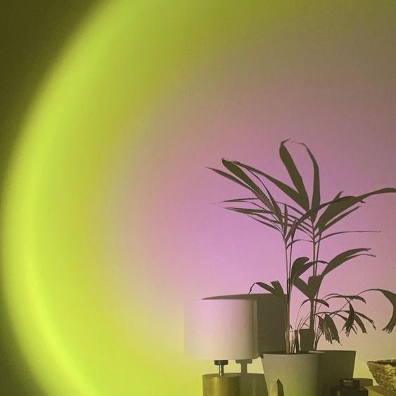 VibeCore Sunset Lamp with a pink interior and green exterior, casting soft pink and green hues on the wall, adding a calming and aesthetic glow to the space.