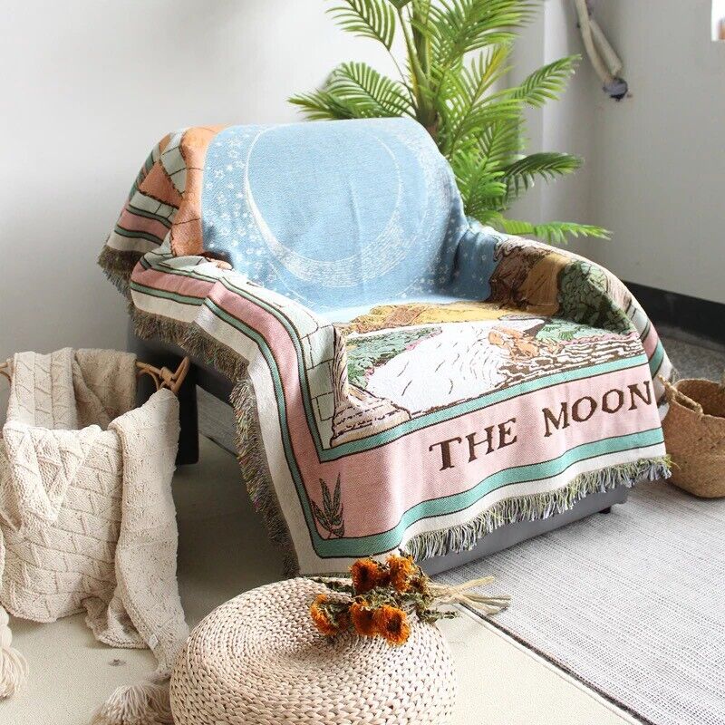 VibeCore The Moon Tarot Woven Blanket draped over chair, featuring celestial-inspired design and soft 100% combed cotton texture.