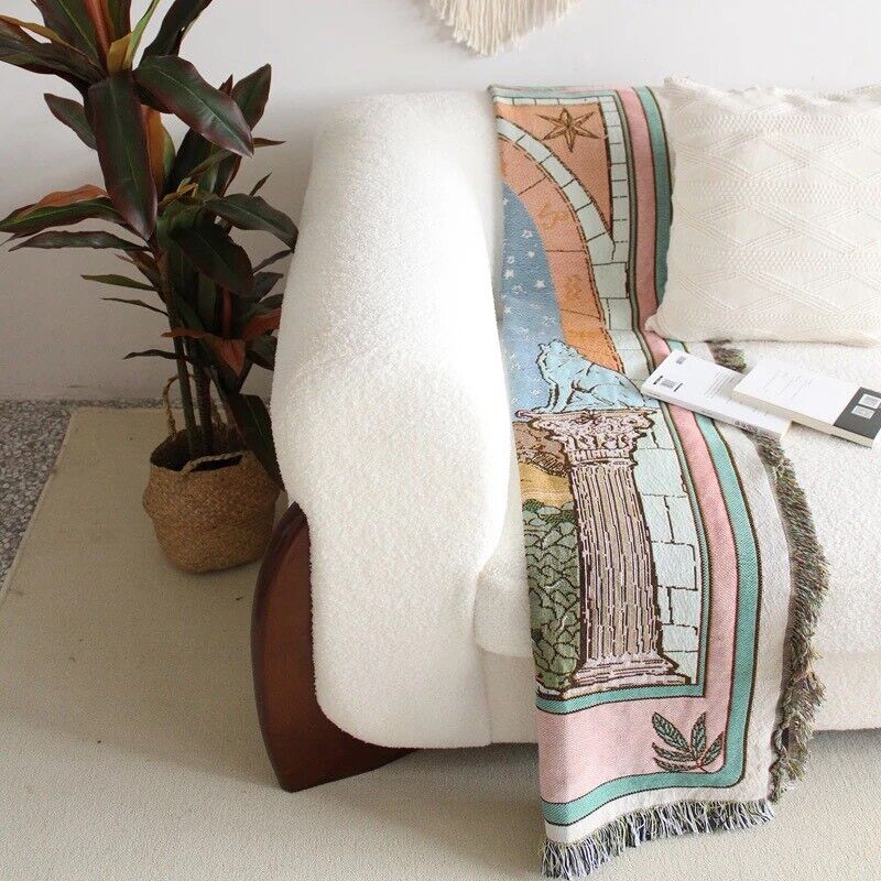VibeCore The Moon Tarot Woven Blanket on couch, folded, featuring celestial-inspired design and soft 100% combed cotton texture.
