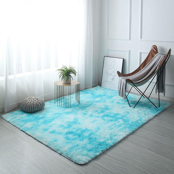 VibeCore Tie-Dye Area Rug Aqua on floor, vibrant aqua tie-dye design, soft polyester fiber construction with non-slip backing, ideal for creating a bold, retro aesthetic in any room.