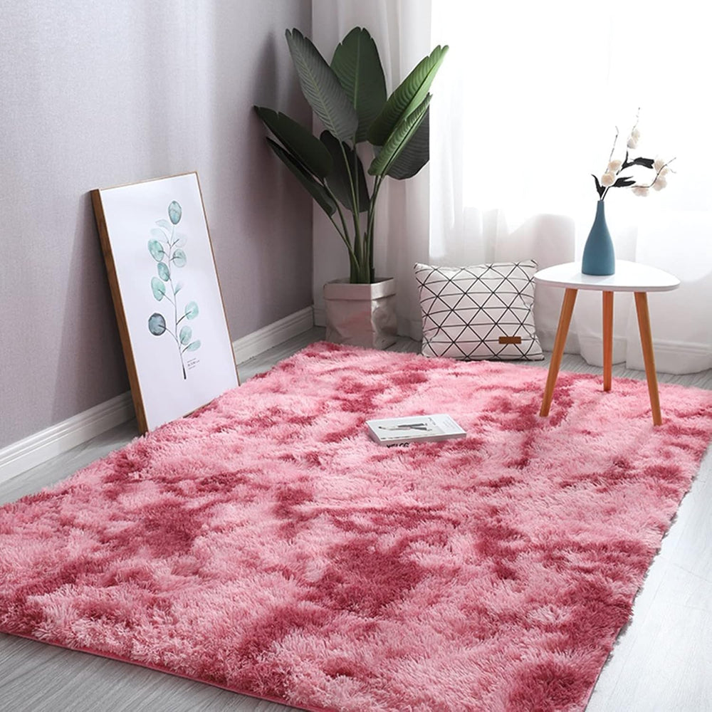 VibeCore Tie-Dye Area Rug Pink on floor, soft polyester fiber rug with vibrant pink tie-dye pattern, non-slip backing for secure placement, ideal for living room, bedroom, and dorm decor.