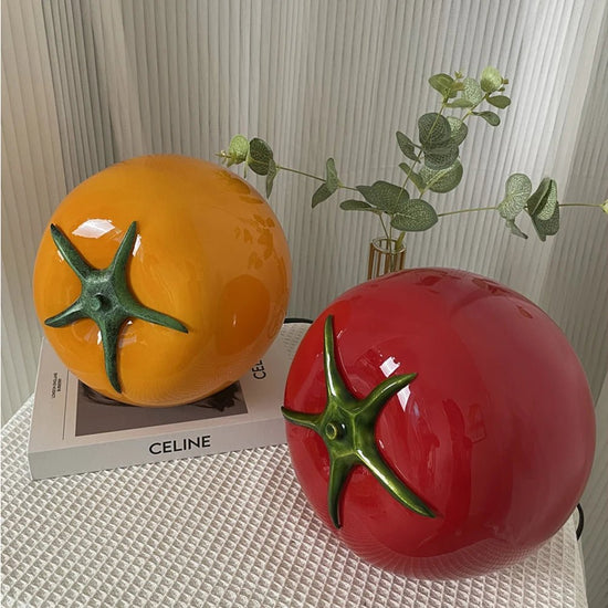 A quirky and vibrant glass table lamp in tomato-inspired yellow and red hues, adding a playful and eclectic touch to any space while emitting a cozy, warm glow.