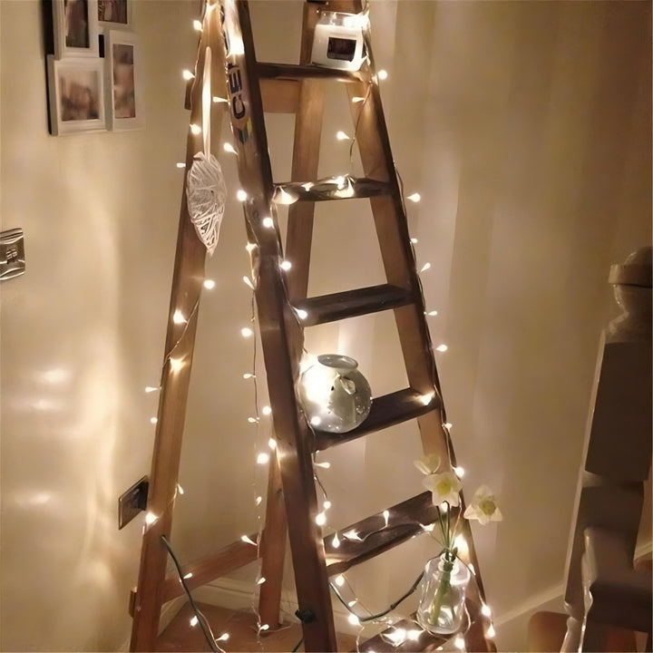 VibeCore traditional string lights in warm white, draped over a ladder, adding a soft, cozy glow to your space for a relaxed, inviting atmosphere.