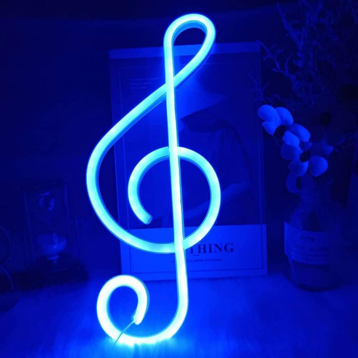 Treble Clef Neon Light in blue, placed on a shelf, casting a vibrant glow that enhances the space with a musical vibe.