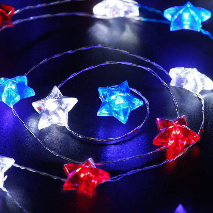 VibeCore Tricolor Stars Fairy Lights on table, creating a vibrant atmosphere with blue, red, and white stars. Battery-powered, featuring 30 lights and 8 light modes for easy customization.