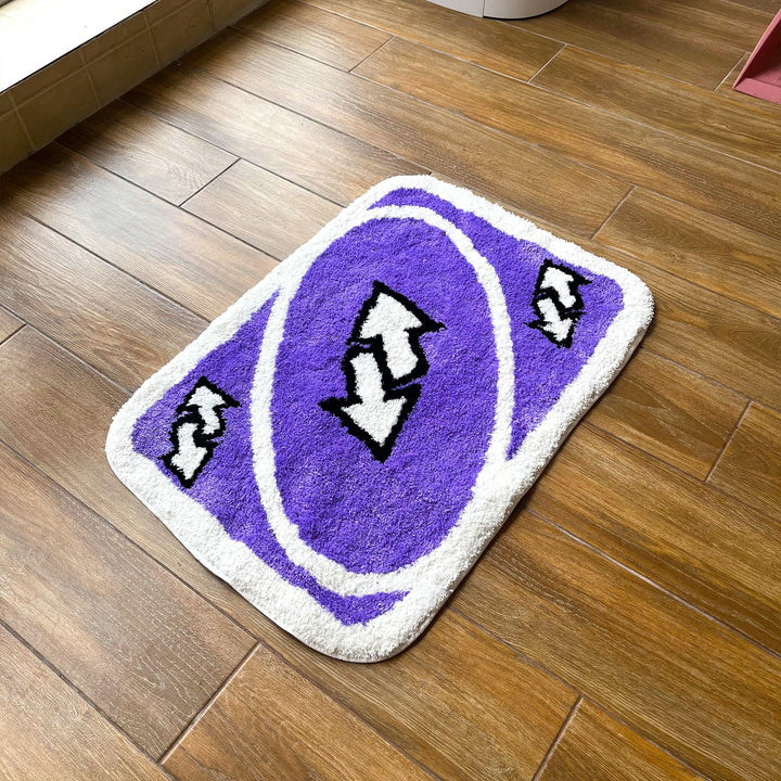 VibeCore UNO Reverse Accent Rug Aerial Side View, showcasing its vibrant purple color and iconic UNO design. This playful rug adds a nostalgic touch while complementing modern decor in any room, bringing both fun and comfort with its soft texture and stylish vibe.