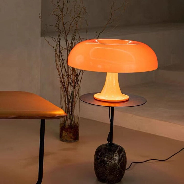 VibeCore Vintage 60s Mushroom Lamp in orange, lit and placed on a side table, creating a warm, nostalgic glow in a stylish living room.