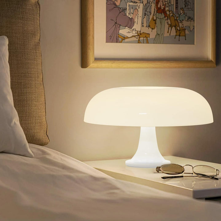 VibeCore Vintage 60s Mushroom Lamp in white, lit up on a bedside table, casting a warm, retro glow in a cozy bedroom setting.