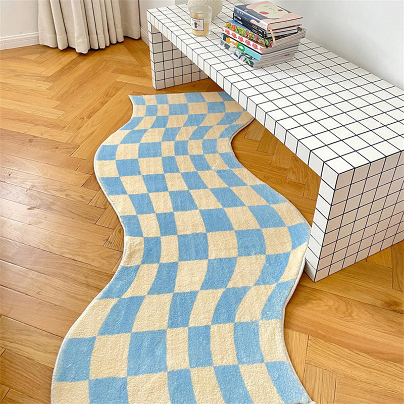 Aesthetic blue "Wavy Checkerboard Accent Rug" displayed on a wooden floor, featuring a dynamic checkerboard pattern with a wavy twist. The soft, plush texture and non-slip backing make it a stylish and functional addition to any space.