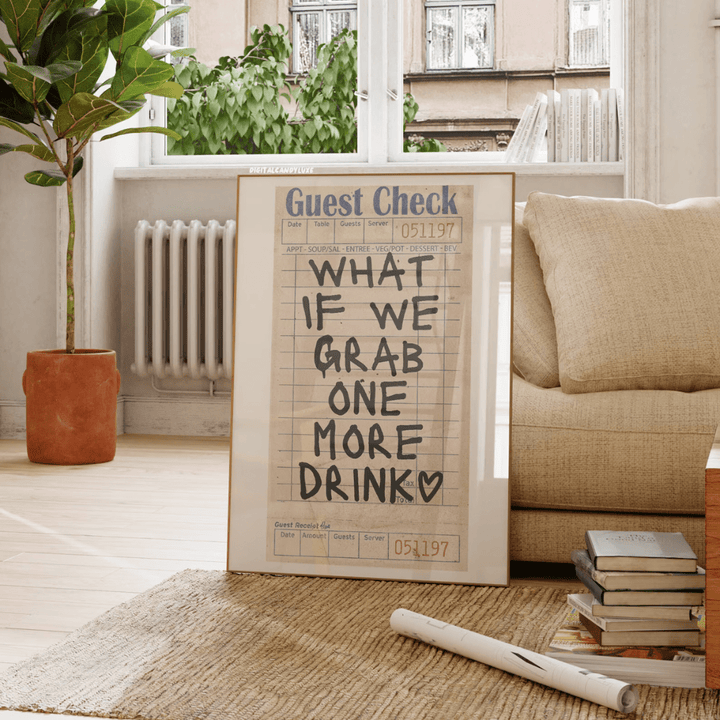 VibeCore 'What If We Grab One More Drink' Canvas Poster front view, leaning against a couch, featuring bold, contemporary handwriting typography with a playful, girly preppy vibe. This retro-inspired design adds a fun and personal touch to your living room, dorm, or apartment. Printed on premium cotton canvas with a semigloss finish for lasting vibrancy and style.