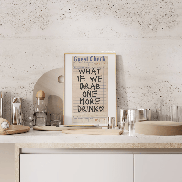 VibeCore 'What If We Grab One More Drink' Canvas Poster front view on a bar, featuring bold, contemporary handwriting typography with a fun, girly preppy vibe. This playful, retro-inspired design adds personality and charm to your bar area or any space in need of cute decor. Printed on premium cotton canvas with a semigloss finish for lasting vibrancy.