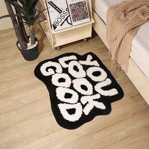Aerial view of the VibeCore You Look Good Accent Rug in black, featuring its uplifting quote design, soft plush texture, non-slip backing, and cute, aesthetic appeal. This modern, stylish rug adds personality, comfort, and a cozy touch to bedrooms, dorms, or living rooms. Perfect for contemporary decor, it’s a fun and unique rug that complements any space with its playful yet elegant design. Ideal for those looking for a vibrant, motivational rug to brighten their home.