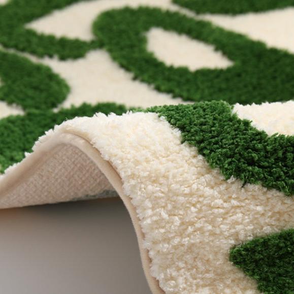 Close-up of the VibeCore You Look Good Accent Rug in green, highlighting its vibrant quote design, soft plush texture, and non-slip backing. This cute rug brings a modern, playful touch to any space, perfect for bedrooms, dorms, or living rooms. Its cozy and motivational aesthetic adds comfort and personality to contemporary decor, making it the ideal rug for those looking to brighten their space with a fun, stylish accent.