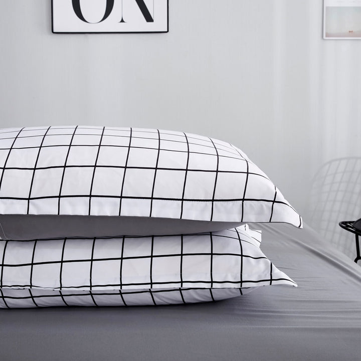 Close-up of pillow covers from the VibeCore Black and White Grid Bedding Set, showcasing the minimalist grid pattern and smooth cotton-polyester blend fabric. Designed for modern bedroom aesthetics, these pillow covers are soft, durable, and fade-resistant, making them the perfect addition to trendy and cozy decor.